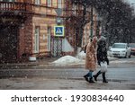 Small photo of people walk through the city in a snowstorm. take shelter from the strong wind. climate change and winter cooling