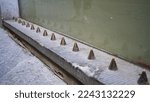 Small photo of Hostile architecture. Metal spikes designed to prevent homeless people to sleep in public places. Defensive architecture.
