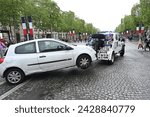 Small photo of Paris, France, 07 May 2023: The towing vehicle takes away an illegally parked car. Car towed away from the tow truck in the city.
