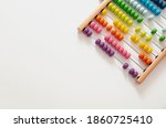School abacus with colorful beads on white color background, close up view, copy space. Kids learning count, children math class concept