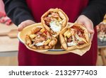 Small photo of Gyro pita Shawarma. Greek food, sliced meat, potato, tomato and tzatziki, paper wrap served in a plate, close up view.