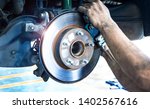 Small photo of Disk brake and car disk brake system service concept - Car disk brake pad replacement service by hand of mechanic man in car garage with flare light effect and copy space