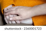 Small photo of Professional doctor supports woman patient holding hands on cozy sweater. Nurse tries to help senior woman to overpower sad and upset feelings