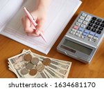 Small photo of Image of a woman filling out a pocket money book