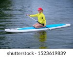 young woman sitting with a paddle on a river, Active healthy vacation concept
