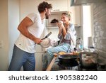 A young couple in love having good time while preparing a breakfast together on a beautiful morning. Cooking, together, kitchen, relationship
