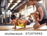 Fitness instructor with girl on training in fitness center