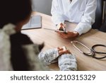 Portrait of a doctor advising clients on health issues holding a tablet to work and talking to patients who come to treatment.