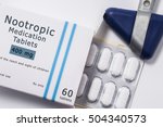 Nootropic drug. Neurological reflex hammer and packaging box of medication with name group of drug Nootropic with blister with pills on white background close up. ?oncept for treatment of migraine