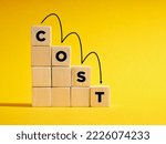 Decreasing costs and cost management concept. Lean, control, reduction, optimization of costs. The word Cost on descending step stairs of wooden cubes.