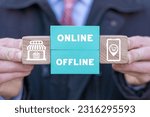 Small photo of Man holding colorful blocks with icons and inscription: ONLINE OFFLINE. Transition from online to offline or vice versa in commerce, business, retail. Choose between online and offline.