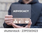 Small photo of Man holding wooden cubes with icons and black sticky note with word: ADVOCACY. Business advocacy and lawyer consulting concept. Advocacy legal service.