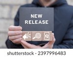 Small photo of Man holding wooden cubes with icons and black sticky note with inscription: NEW RELEASE. New release concept. New product development. Update software version.