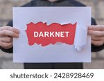 Man holding white and red sheets of paper with text: DARKNET. Darknet and cybersecurity concept. Darknet browser deep dark web net internet technology.