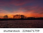 Beautiful colorful clouds after sunset over trees and lake water, Stankow, Poland
