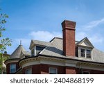 Small photo of Brick chimney and gabled dormer windows of a house in a sunny day, Brookline, MA, USA