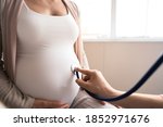 Happy pregnant woman visit gynecologist doctor at hospital or medical clinic for pregnancy consultant. Doctor examine pregnant belly for baby and mother healthcare check up. Gynecology concept. 