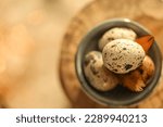 Small photo of Quail eggs.Feathers on quail eggs in a blue cup.Organic farm products.Animal protein.Organic farm natural quail eggs set in the rays of the sun.