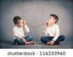 Young brothers talking with tin can telephone on grunge background.
