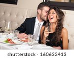 Attractive elegant young couple drinking a cocktail at the restaurant.