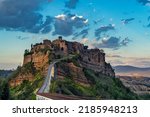 Civita di Bagnoregio, ancient medieval village in central Italy with dramatic sky at sunset. Now a major touristic attraction.