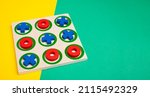 Small photo of tic-tac-toe board game concept on yellow and green background with copy space