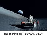 Astronaut near the moon rover on the moon. With land on the horizon. Elements of this image were furnished by NASA. High quality photo
