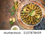 Small photo of Arabic Cuisine; Traditional delicious stuffed vine leaves. Served with yogurt salad and fresh lemon. Top view with copy space.