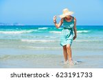 Beautiful young woman in summer dress on the beach