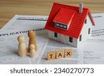 Small photo of House or building or land value property tax, local development tax concept : Word tax, home model