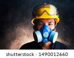Gas mask. Respirator cartridge. Man in factory with backdrop - close up