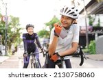 asian woman holding a bottle of water while sitting on her bike