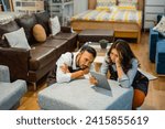 Small photo of shopkeeper man and woman using a tablet looking lethargic after a day at work in furniture store