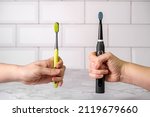 Small photo of Electric and regular toothbrush in a bathroom. Dental care. Manual toothbrush against modern electric toothbrush concept.