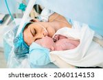 Small photo of The first moments of mother and newborn after childbirth. Newborn child seconds and minutes after birth. Premature baby boy delivered by Caesarean section, being shown to his mother.