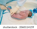 Small photo of Newborn baby after delivery in labor room. Doctor and midwife measure height newborn boy after birth in hospital. Medical examination of the newborn in the first few minutes of life.