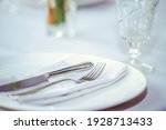 restaurant table setout with white plates and silverware.