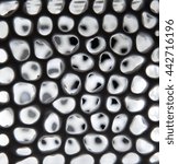 Small photo of Background of dark smooth transparent porcelain cell surface with rounded holes shining bright from inside and resembling organic structure