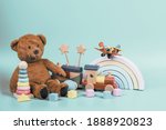 Kids toys collection. Teddy bear, wooden rainbow, train and baby toys on light blue background. Front view