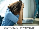 Small photo of woman sitting down, his face unsettled. At the computer desk she has headaches and stress. Cause of hard work and insufficient rest.