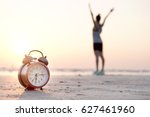 Morning of a new day, alarm clock  woman playing yoga and stretching muscles on the beach sunlight in morning. Health concept.