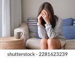 A young woman feeling sad and stressed, sick and headache at home