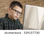 Boy With Glasses Using Laptop...