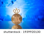 Metallic bitcoin coin with shiny crown on blue background. Bitcoin leadership business concept. Virtual crypto queen currency.