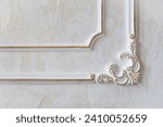 Small photo of Plaster molding on the wall in the shape of a frame with gold paint. Sena with white decorative plaster and silver patina. Close-up details of a modern interior.