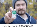 Small photo of KHARKOV, UKRAINE - OCTOBER 26, 2019: Young man shows new Tic tac hard mints package in autumn park. Tic tac is popular due its minty fresh taste by Ferrero since 1968