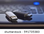 USB flash cards lying on black laptop case in front of his keyboard. Virtual memory storage with USB output