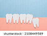 Small photo of Impacted wisdom teeth with healthy tooth cartoon made from paper. Dental problems associated with wisdom teeth include tooth decay, jaw pain, oral infection or gum disease. Creative idea.