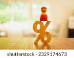 Small photo of Red person model and big percent sign. Discount, loyalty program, promotion. Good interest rate. Lending of organization or entity. Personal loans with interest-free periods, Bank loan concepts.