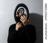 Small photo of Enigmatic surrealistic optical illusion, young man holding round frame on textured grey background. Contemporary artwork collage concept.